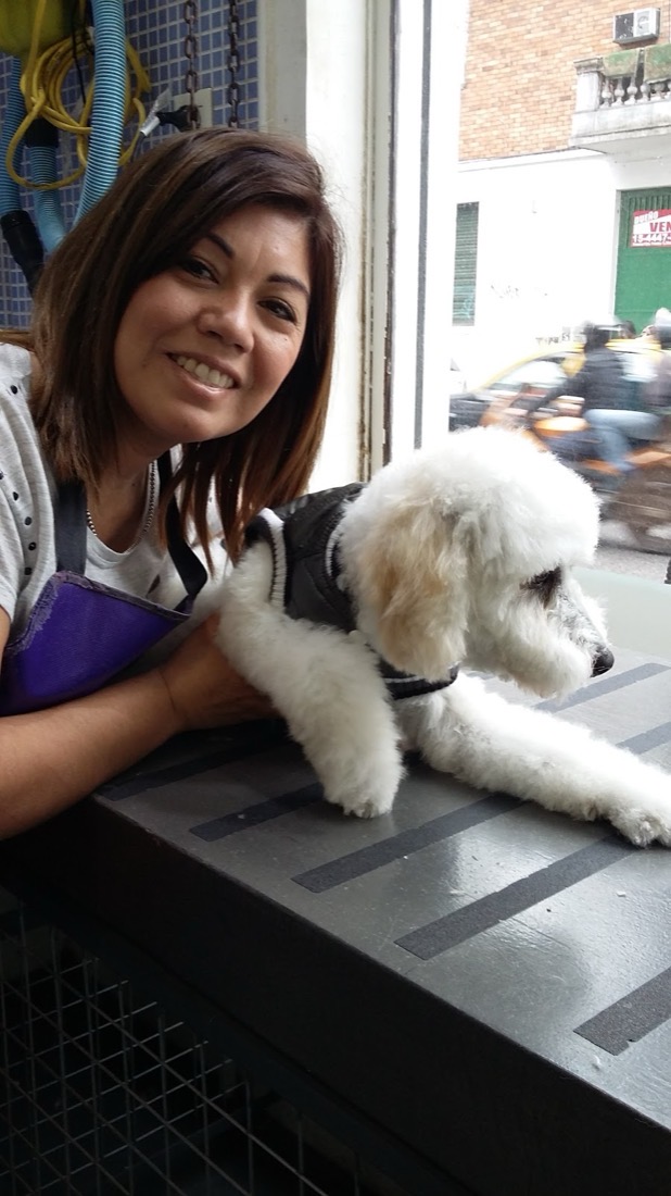 Peluquera del salón de belleza canino junto a un caniche